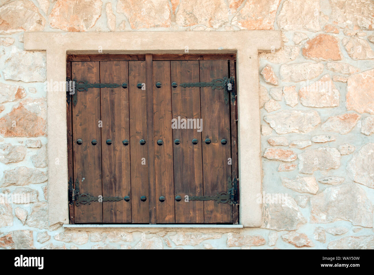 Window shutters on old stone wall. Building facade wall with wooden ...