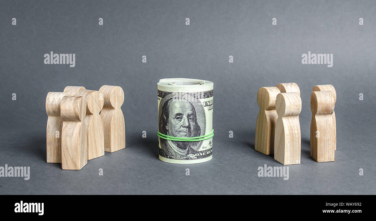 Two groups of people are divided by a bundle roll dollars. Investment concept. High profits and a welcome item. The cult of money, capitalism. Financi Stock Photo