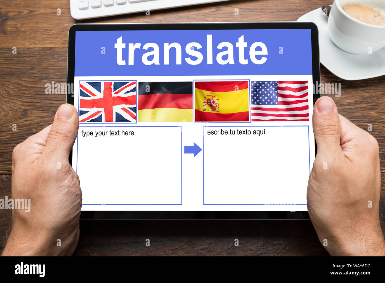 Person's Hand Holding Digital Tablet Showing Language Translate Application With Country Flag Stock Photo