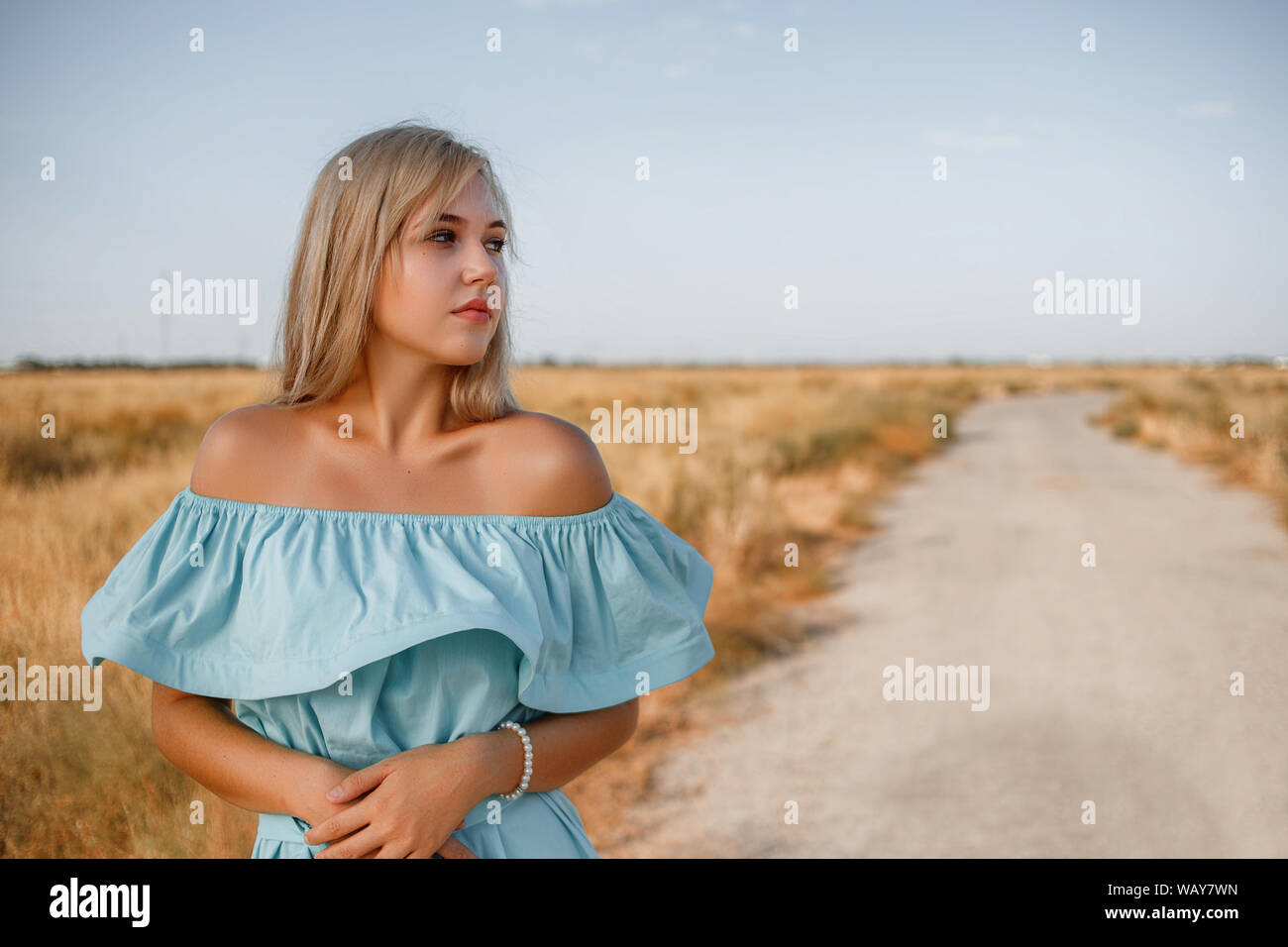 portrait of a young beautiful caucasian blonde girl in a light blue ...