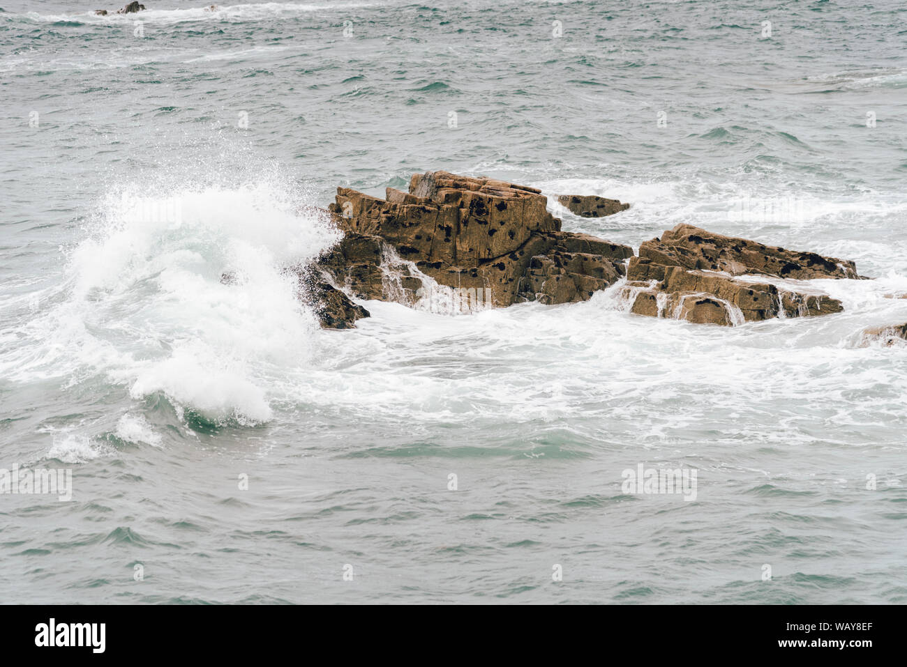 Scenic view of waves splashing against rocks in the Pink Granite Coast ...