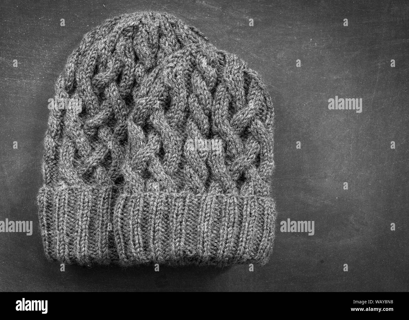 Hand knitted pair of woolen hats with lots of cables.  One for an adult and one for a child. Stock Photo