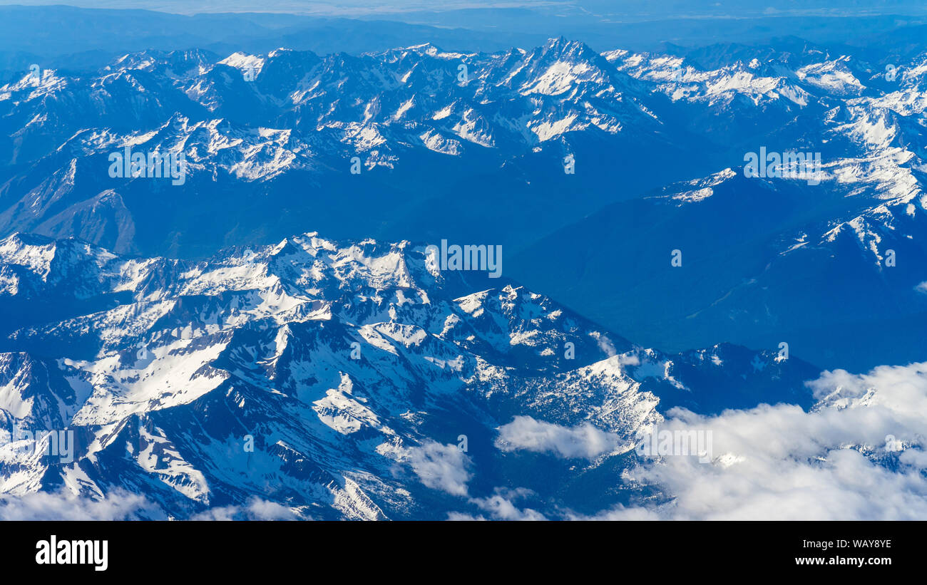 Central Cascades with small clouds from airplane approach in Seattle Stock Photo