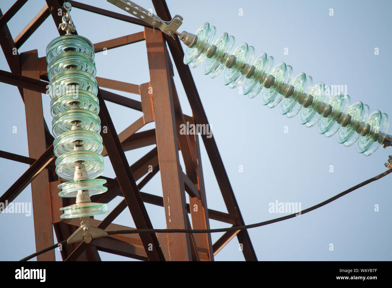 Close up bottom view of insulators on high-voltage wires on a power ...