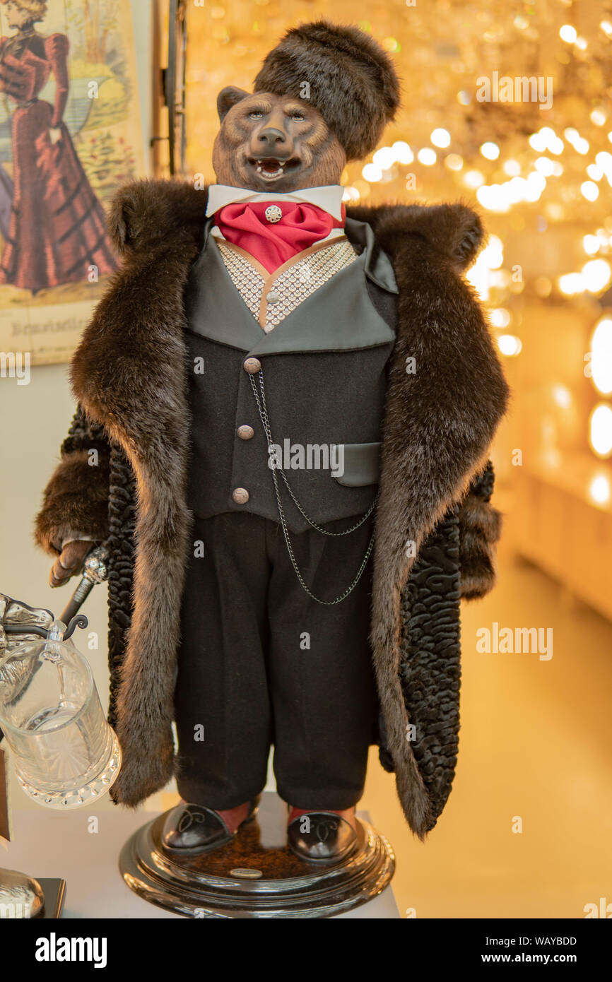 Bear in a fur coat stands on his feet in red clothes. Mannequin tall and handsome. Stock Photo
