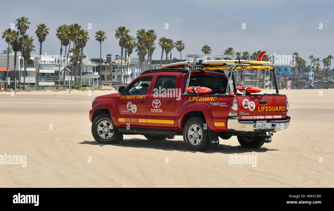 LOS ANGELES, CA / USA - MAY 23, 2017: A lifeguard patrolling in a vivid red Toyota Tacoma special off road pick up truck on Venice Beach, Stock Photo