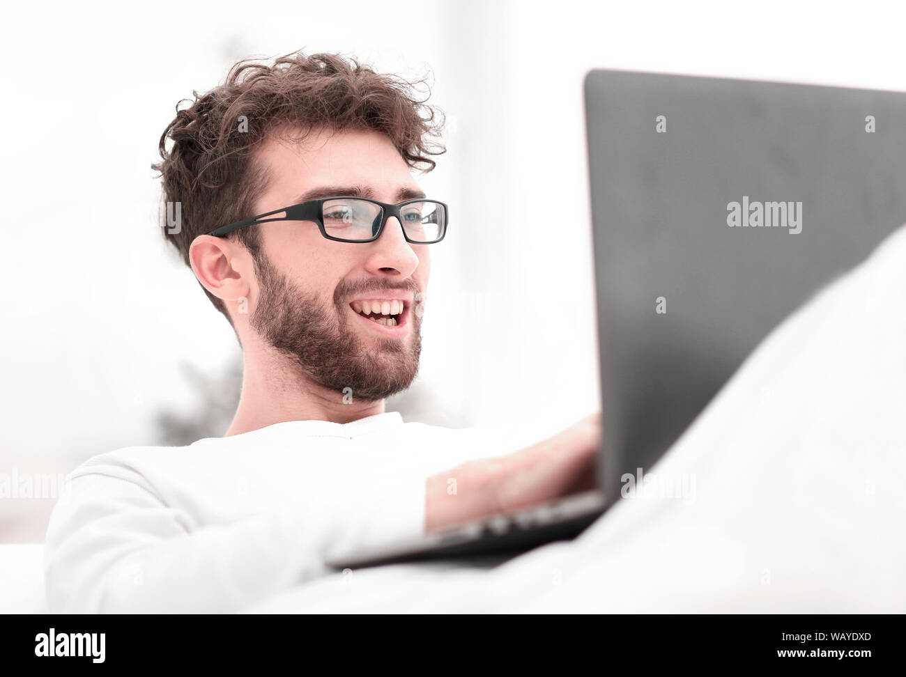 handsome man working on laptop lying on bed Stock Photo - Alamy