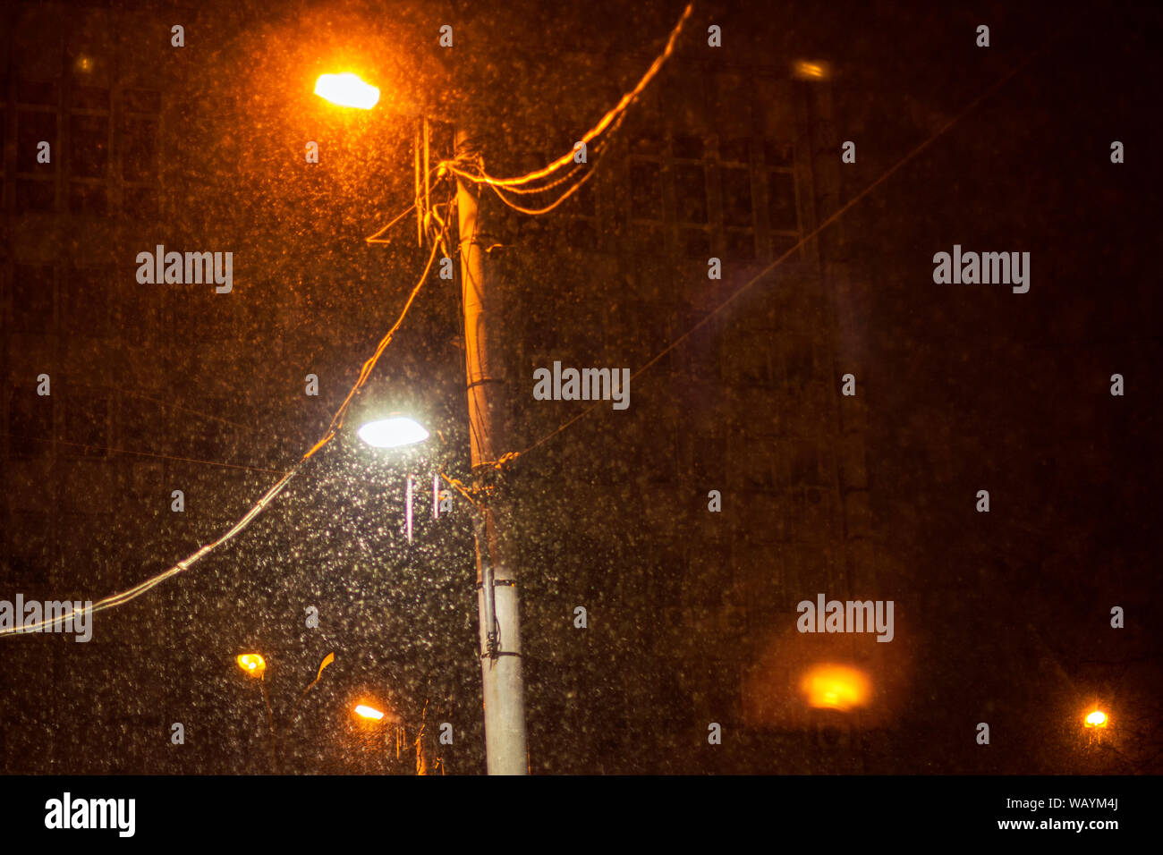 street lamps lighting and snow falling in the night Stock Photo - Alamy