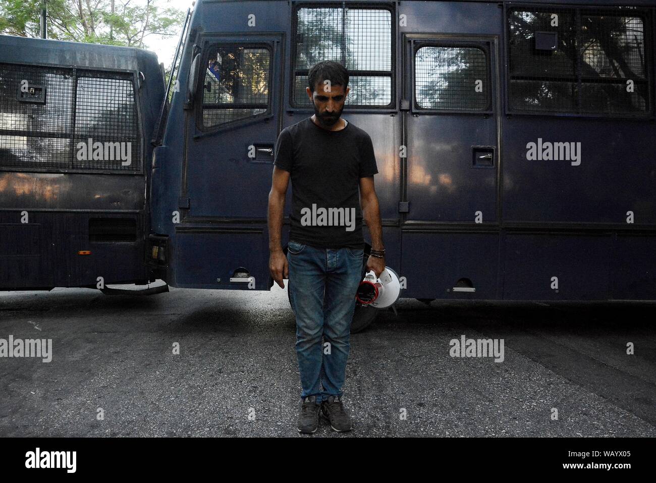 A Kurd protester stands before a police bus during the demonstration against the removal of the Municipal Co-chairs of the Kurds party known as HDP, who were elected in Diyarbakir and Mardin, by the Interior Ministry of Turkey. Stock Photo