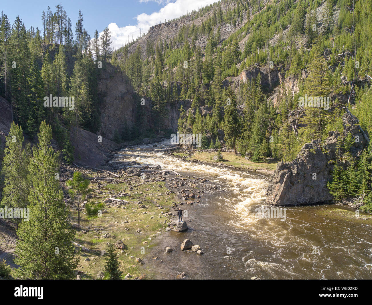 Yellowstone River running through the canyon during summer day with blue sky and clouds Stock Photo