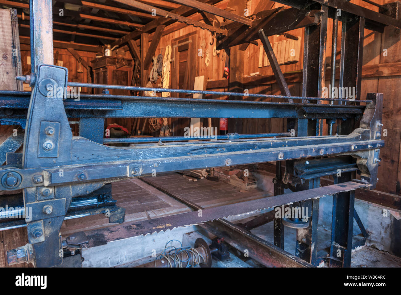 View into an old woodshed with gate saw in the foreground. Stock Photo