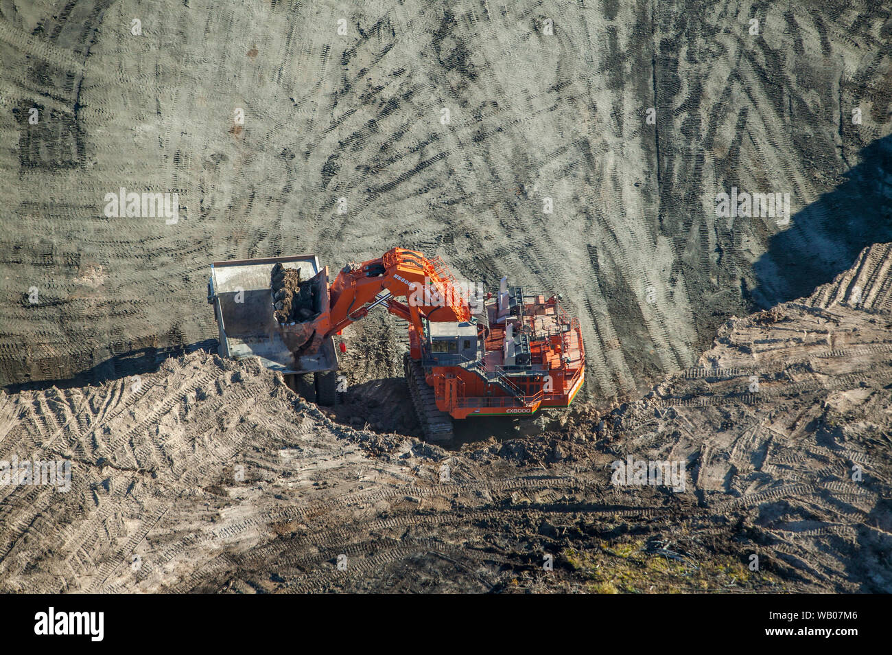 Shovel loading giant truck with bitumen rich ore at CNRL Horizon mining operations near Fort McKay, Alberta, Canada. Stock Photo