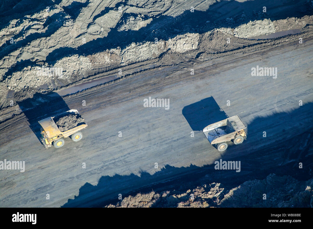 Giant trucks haul bitumen rich ore from mining operations to oil sands plants for processing and exctraction north of Fort McMurray, Alberta, Canada. Stock Photo