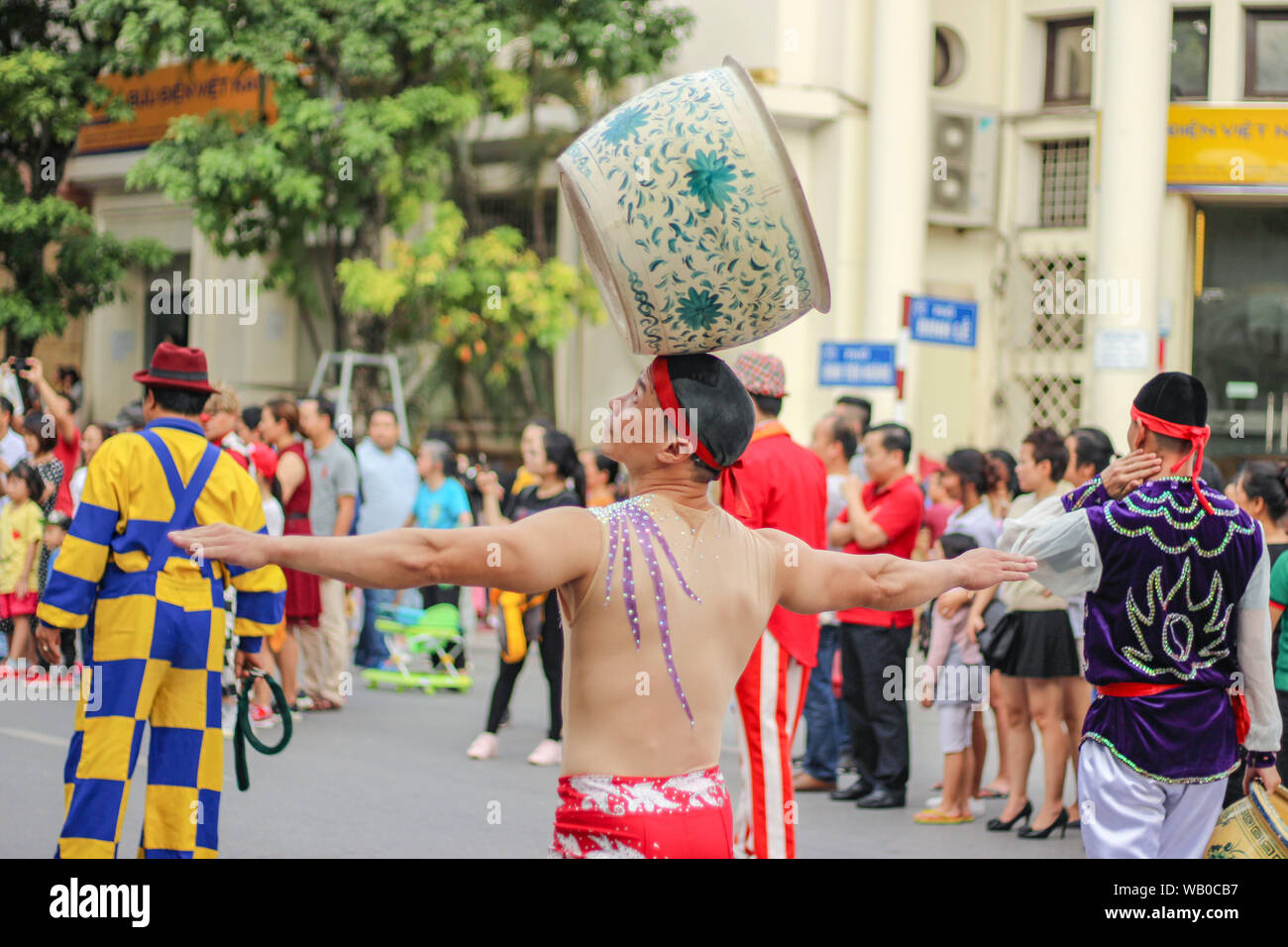 A man carries a big ceramic pot on his head in the festival in Hanoi, Vietnam. Stock Photo