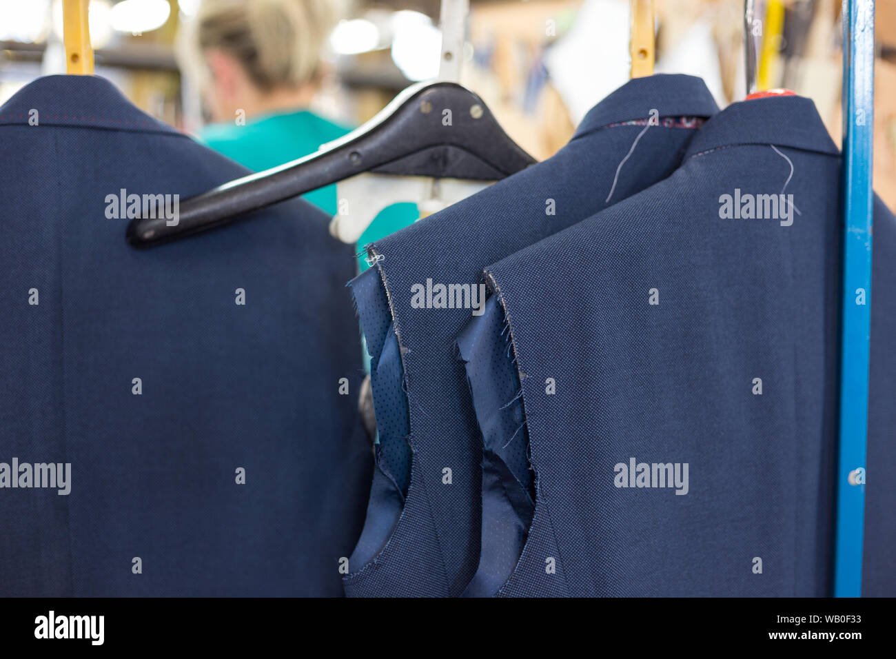 Unfinished suit jackets hanging on assembly line in European garment