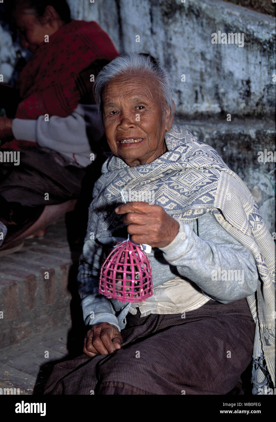 a south east eastern woman with a bird in cage as a  religious symbol Stock Photo
