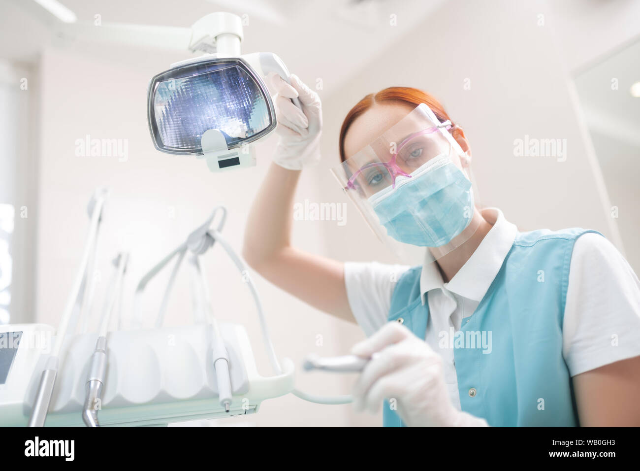 Female dentist wearing protective glasses examining patient Stock Photo