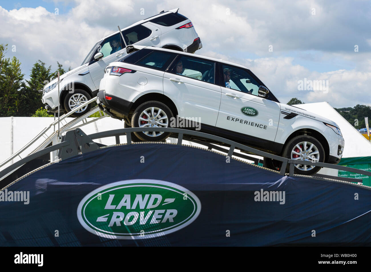 Land Rovers (Range Rover & Discovery) driving on high thrilling steep descent - Land Rover Experience display course Great Yorkshire Show, England, UK Stock Photo