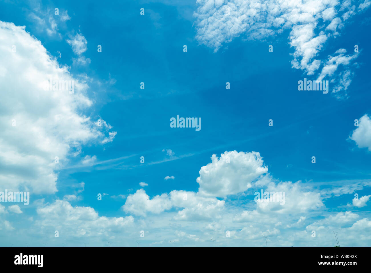 Beautiful blue sky and white cumulus clouds abstract background. Cloudscape background. Blue sky and fluffy white clouds on sunny day. Nature weather. Stock Photo
