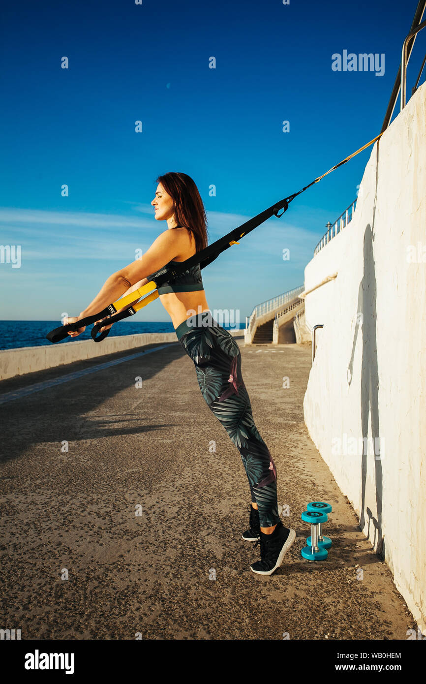 young sporty woman doing TRX in the outdoor Stock Photo