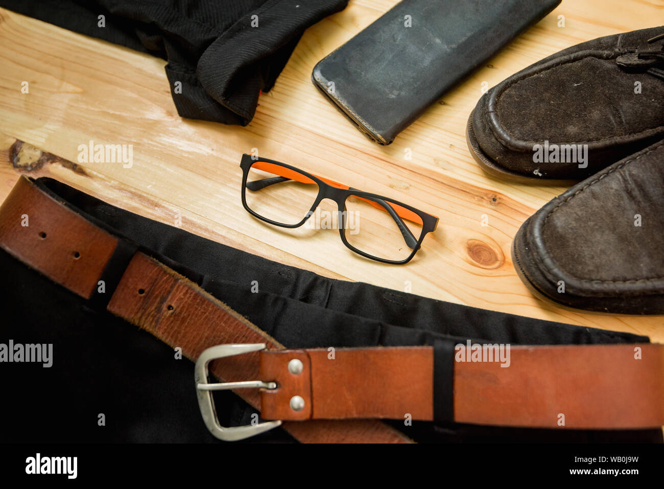 man casual outfits fashion accessories wooden table, (shirt,jean,wallet,sunglasses,glasses,Belt,shoes) Stock Photo