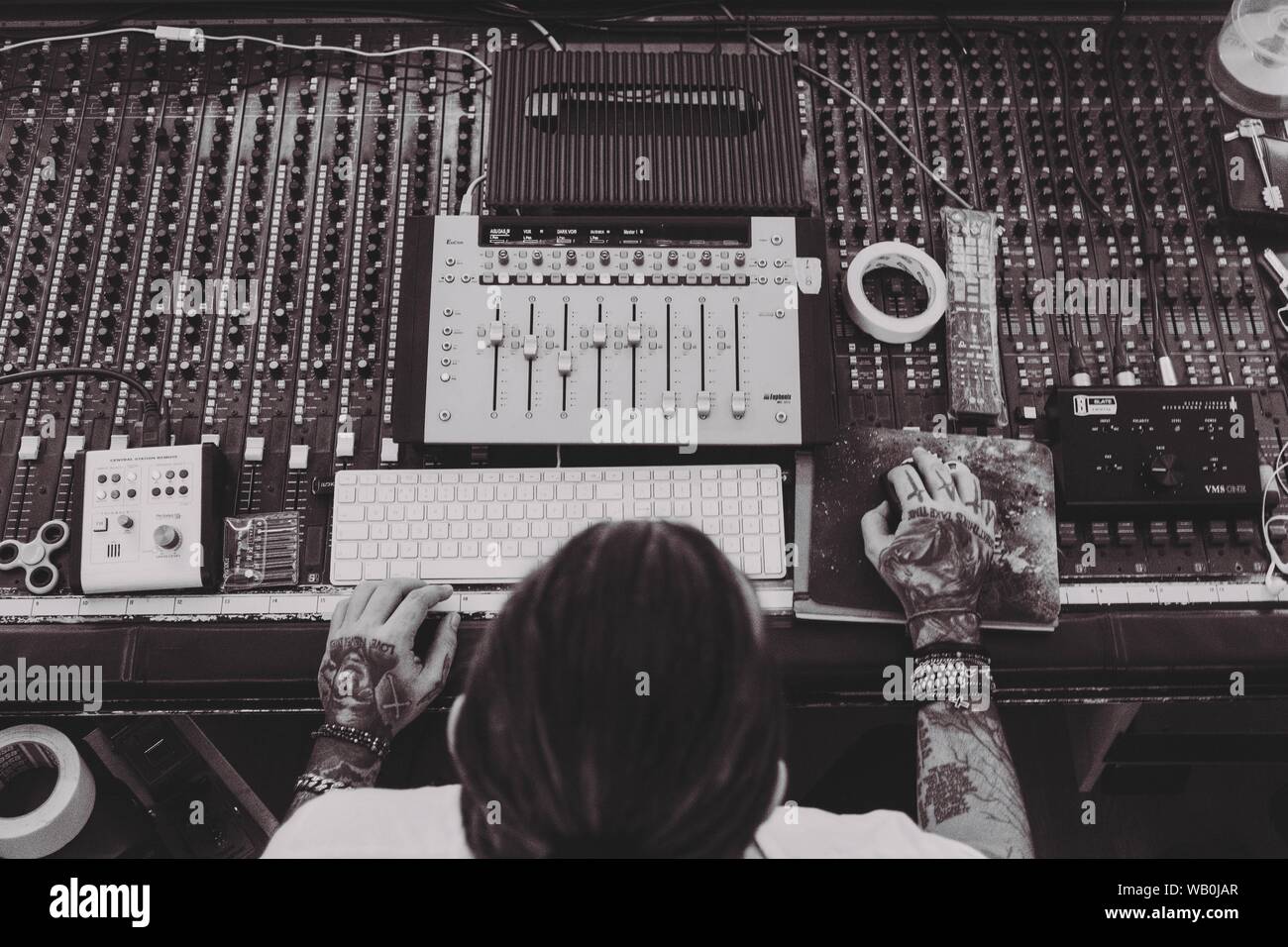 Overhead shot of a male working on mixing console and other recording