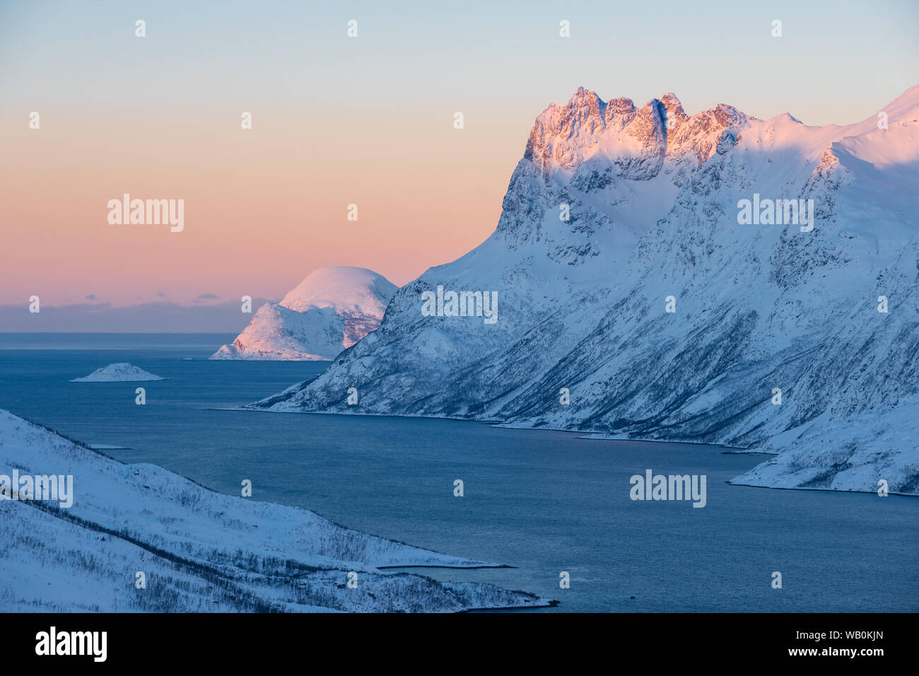 Arctic landscape: Snowcapped mountain skamtinde in winter in fjord at sunrise, Ersfjord Norway Stock Photo