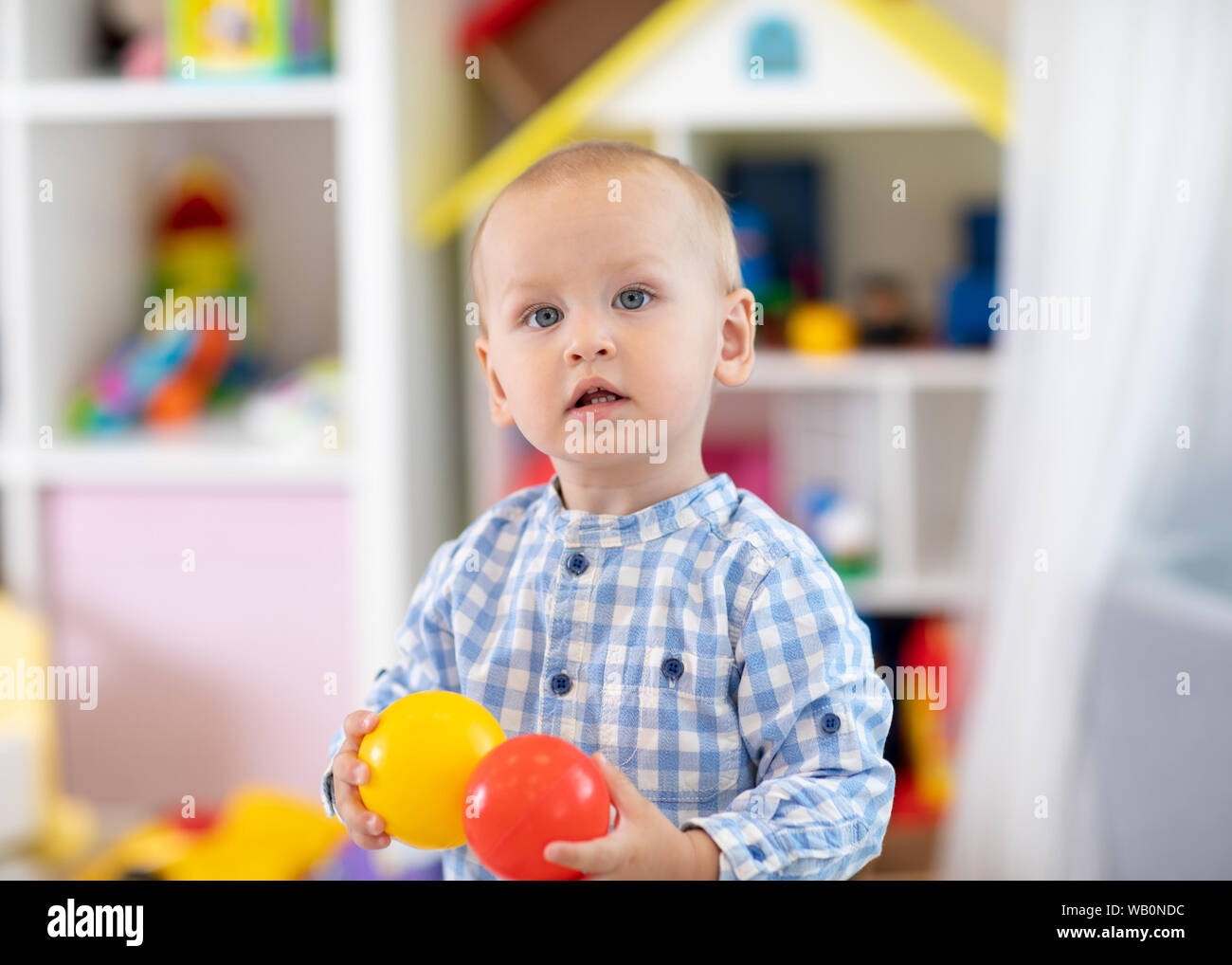 Portrait of pretty baby boy in kindergarten. Nursery child toddler is happy Stock Photo