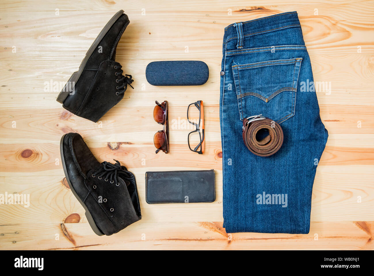 man casual outfits fashion accessories wooden table, (shirt,jean,wallet,sunglasses,glasses,Belt,shoes) Stock Photo