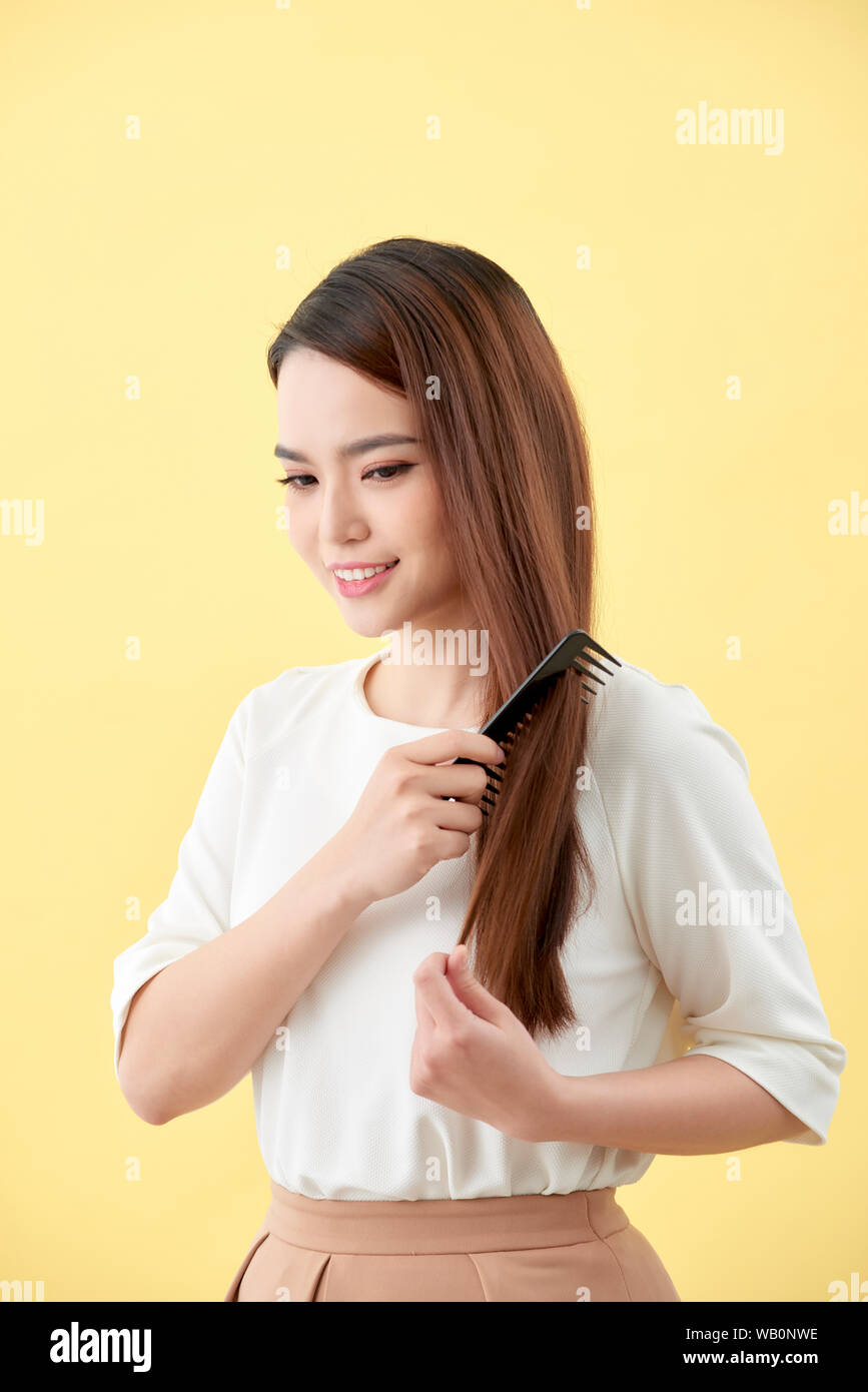 young beautiful woman combing her hair in living room Stock Photo