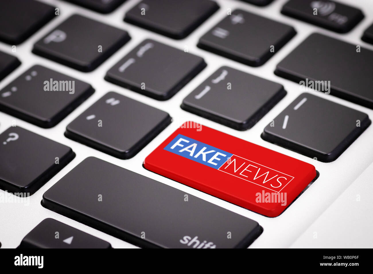 red fake news button on laptop keyboard. fake news on internet in modern digital age concept Stock Photo