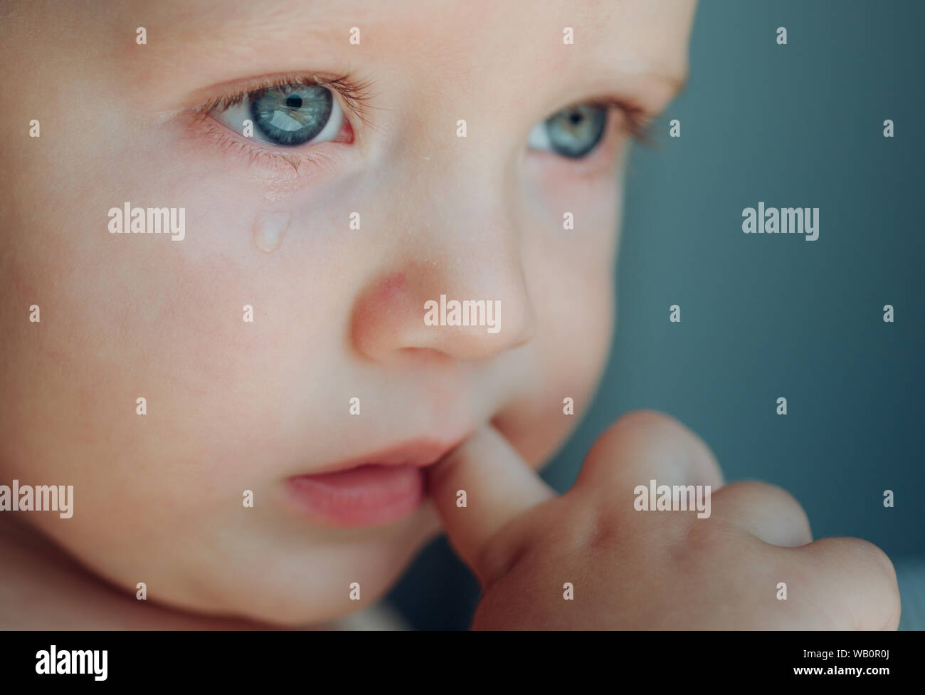 Feeling weepy. Baby with tear rolling down his cheek. Little boy child