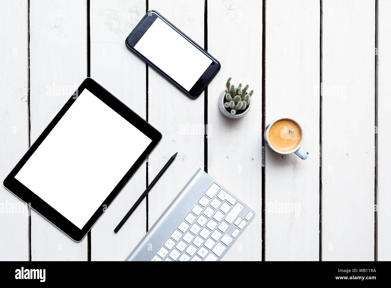Office objects, devices with blank screens. White screen on smartphone and tablet on wooden table Stock Photo