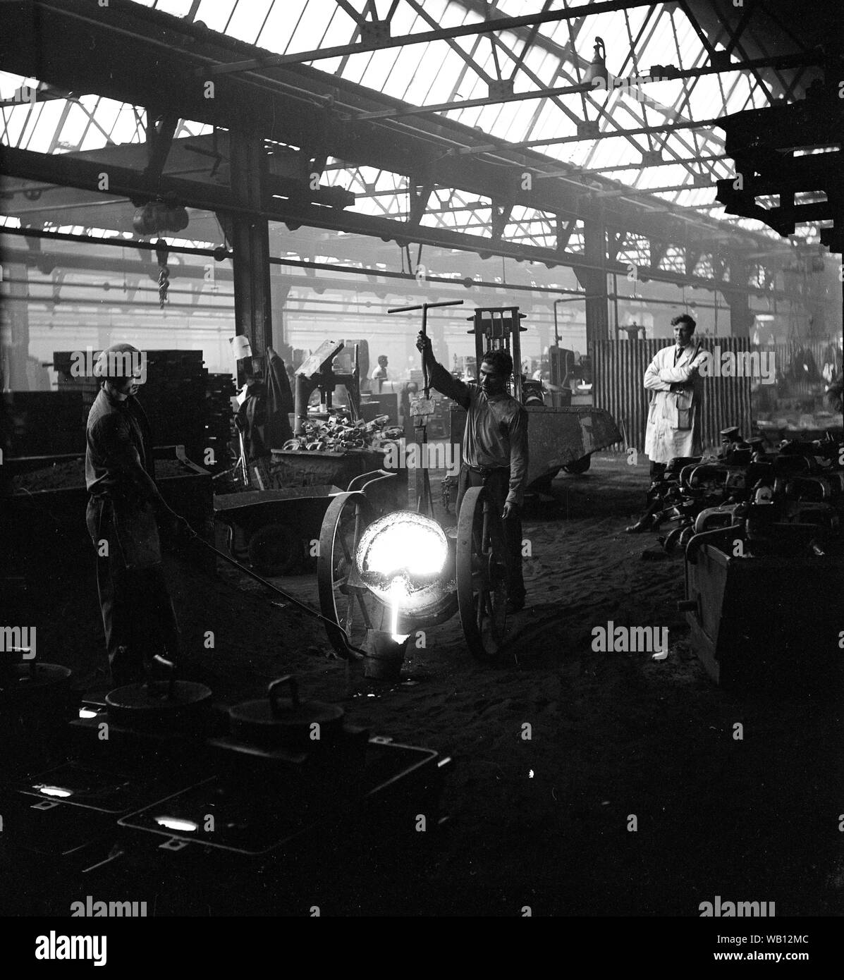 Iron foundry workers pouring molten metal Britain 1964 Stock Photo