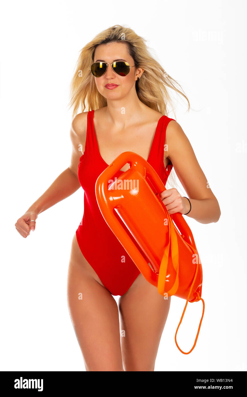Pretty young woman lifeguard in red sexy swimsuit with lifeguard rescue can floating buoy tube on the white background. Concept Woman in Swimsuite. To Stock Photo
