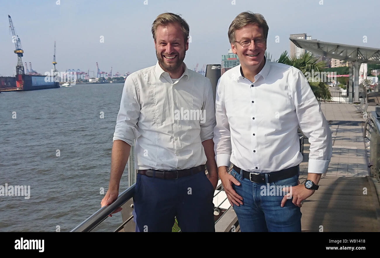 23 August 2019, Hamburg: The faction leader of Bündnis 90/Die Grünen, Anjes Tjarks (l), and the faction leader of the SPD in the Hamburg Parliament, Dirk Kienscherf, are standing at the Landungsbrücken. Social Democrats and Greens in Hamburg and Rotterdam want to promote cooperation between the two port cities in reducing air pollutants emitted by seagoing ships. Photo: Martin Fischer/dpa Stock Photo