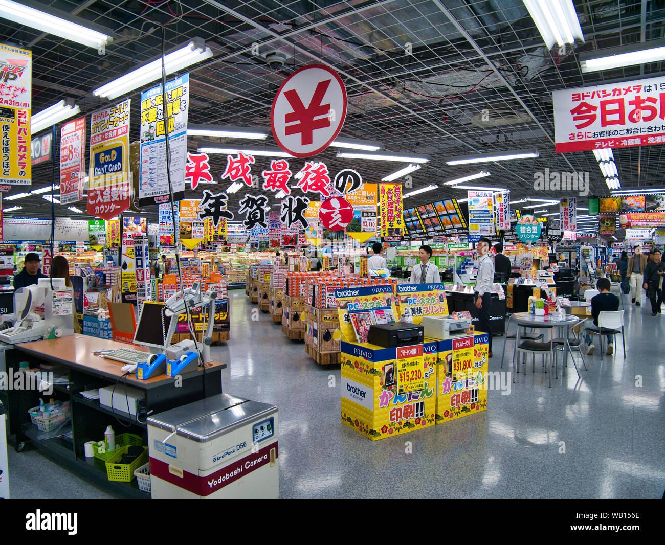 The interior or inside of a Japanese store, selling technology items in Kyoto, Japan. Many store assistants are waiting to serve customers. Stock Photo