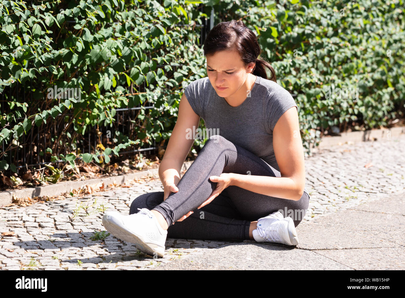 Close-up Of A Female Runner Suffering From Pain In Calf Muscle Stock Photo