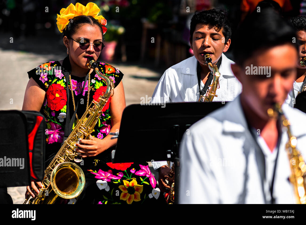 A Mexican girl of Zapotec origin, wearing traditional Tehuana dress, plays saxophone during the festival in Juchitán de Zaragoza, Mexico. Stock Photo