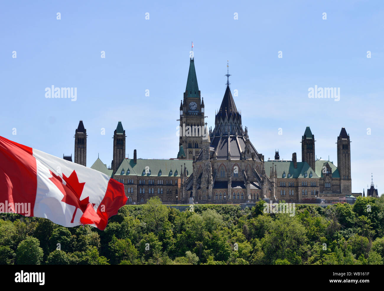 View of Canadian Parliament Hill from back side with Canada flag on left Stock Photo