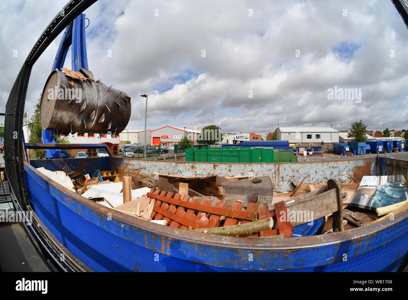 hydraulic arm crushing wood in container at household waste recycling centre united kingdom Stock Photo