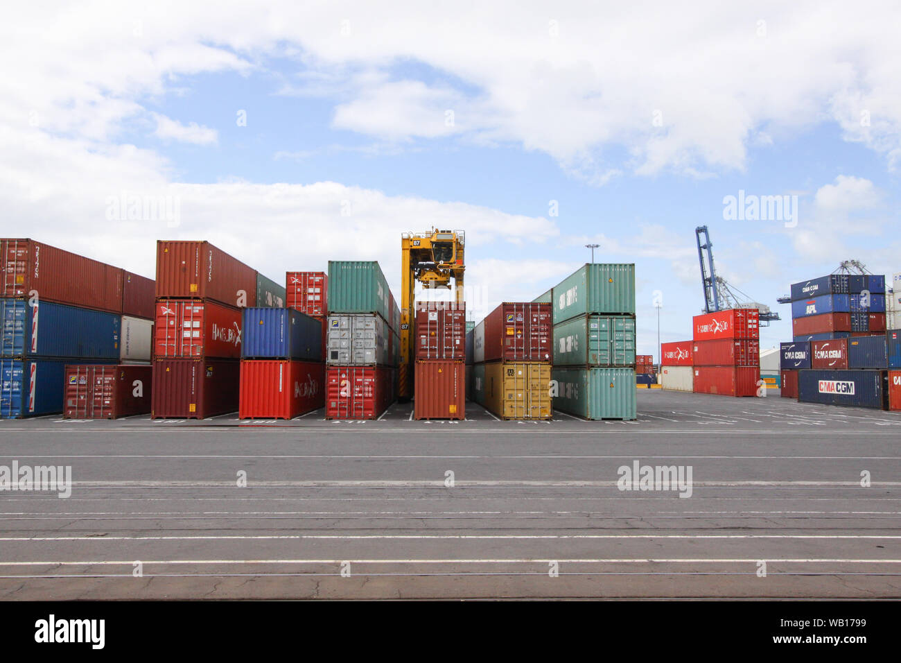 Straddle Carrier (Van Carrier) lifting up a container in the harbour of  Auckland, New Zealand Stock Photo - Alamy