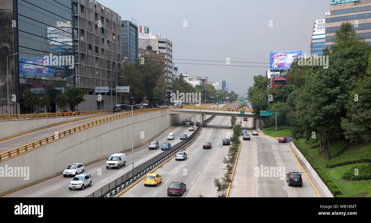 View over the top of a motorway running through the centre of Mexico City, with office blocks on either side. Stock Photo