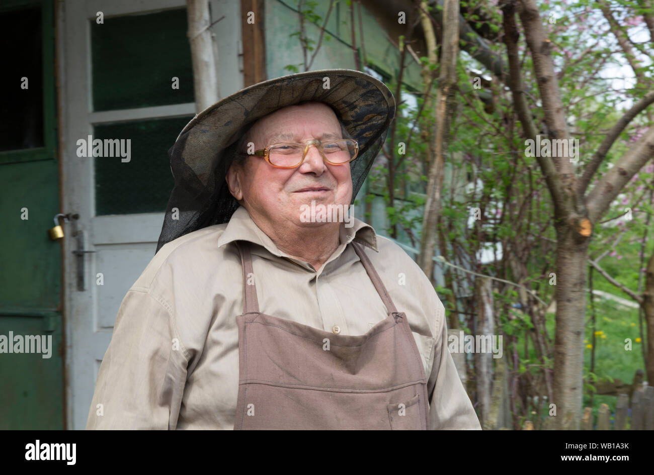 Rumania, Ciresoaia, Portrait of smiling beekeeper with beekeper's hood Stock Photo