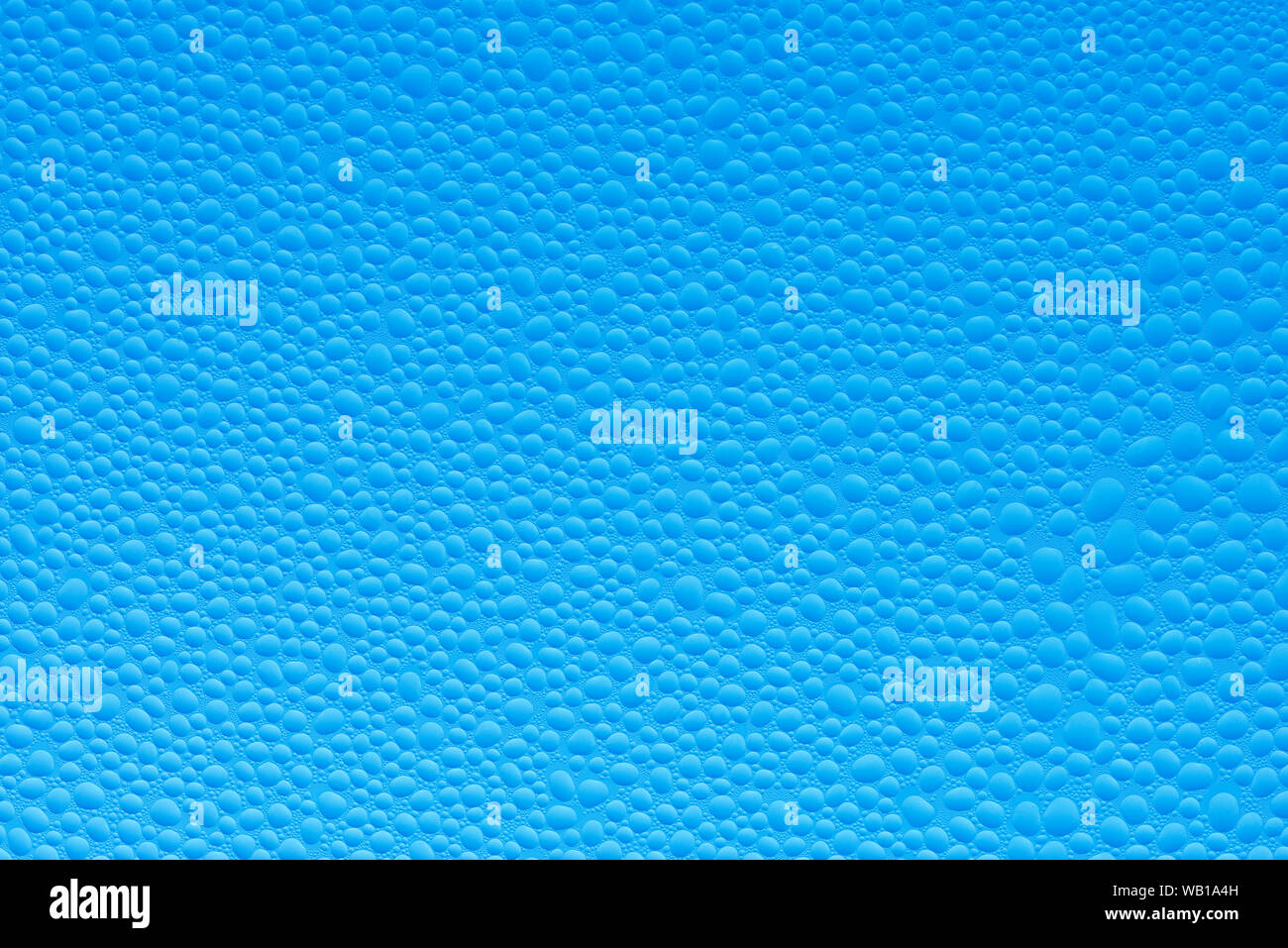 Drops of water on a glass window of a car against clear blue sky, close-up Stock Photo