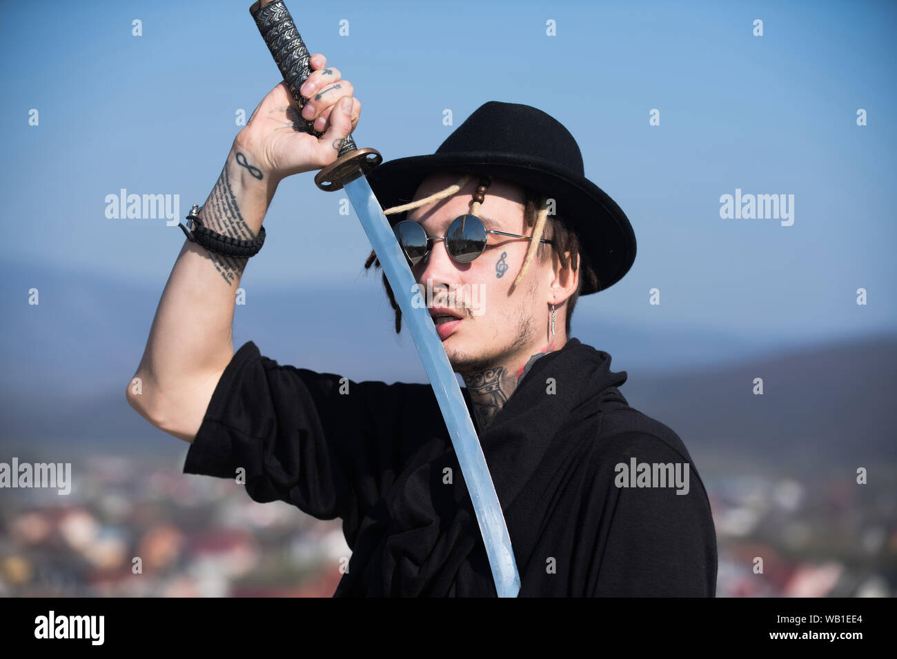 Defense, power, honor, force. Samurai with japan katana weapon outdoors. Man holding sword with metal blade on blue sky. Martial arts concept. Warrior Stock Photo