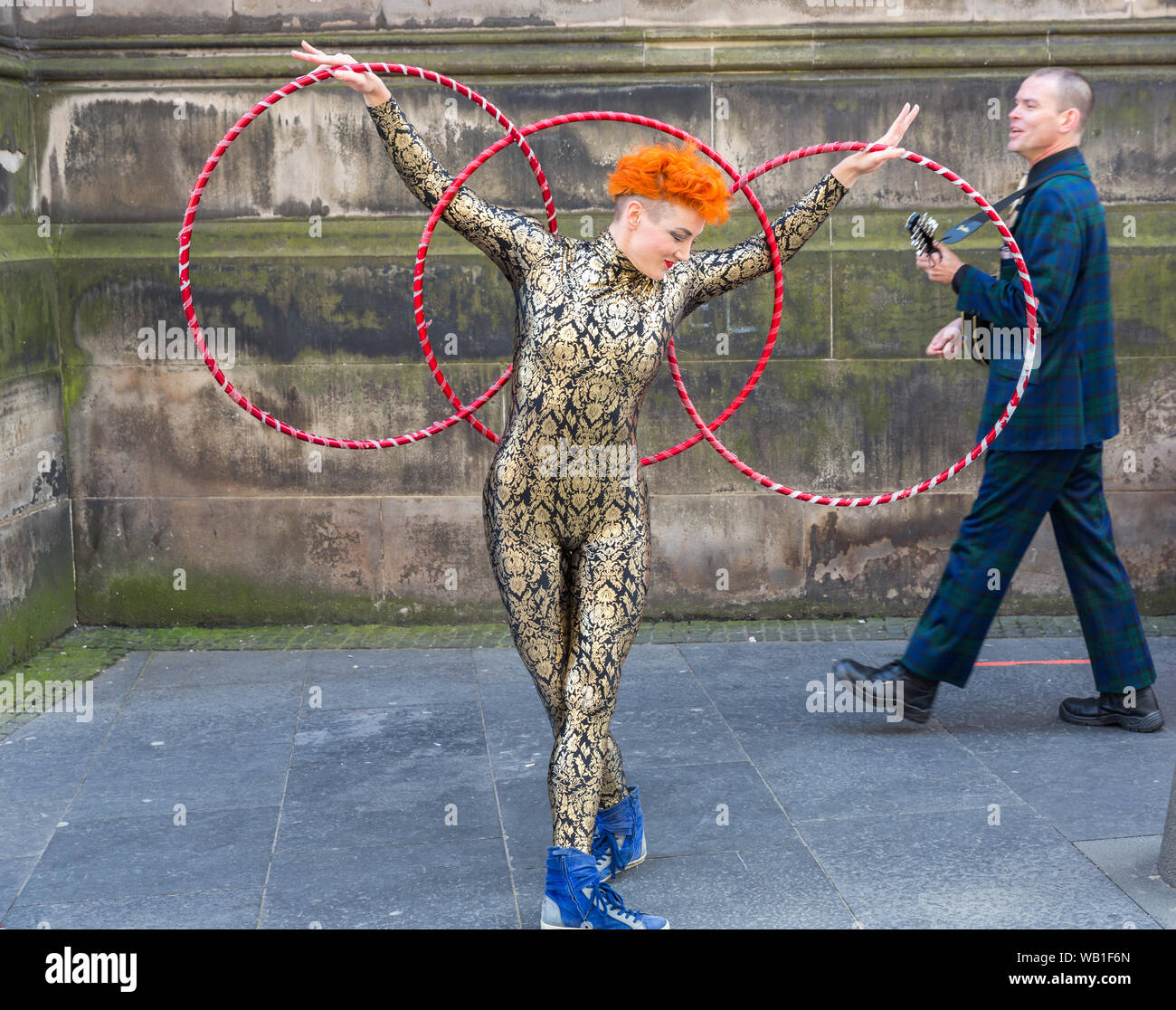 A street performer doing gymnastic dance with hoola hoops at the Edinburgh Festival Fringe 2019 Stock Photo