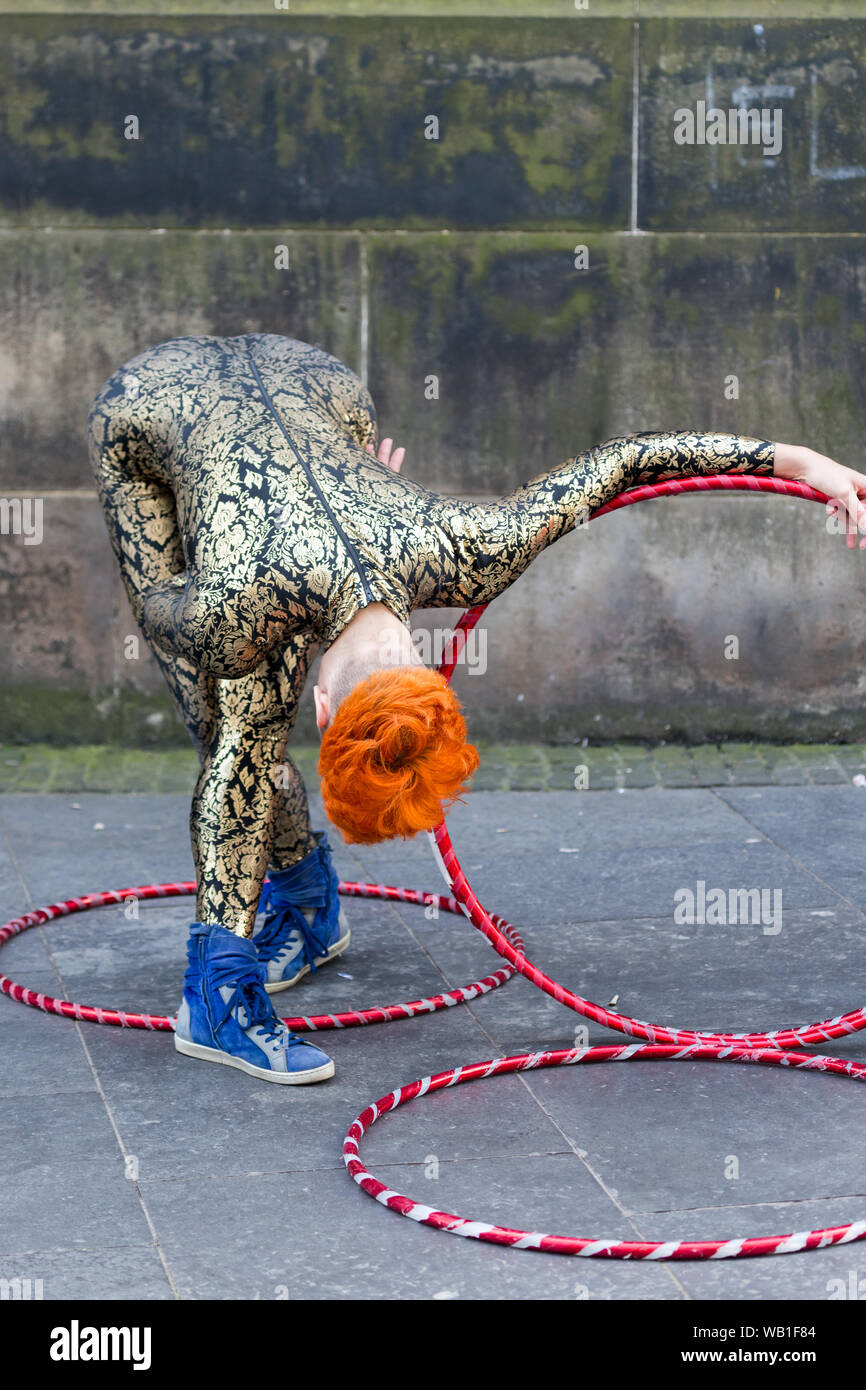 A street performer doing gymnastic dance with hoola hoops at the Edinburgh Festival Fringe 2019 Stock Photo