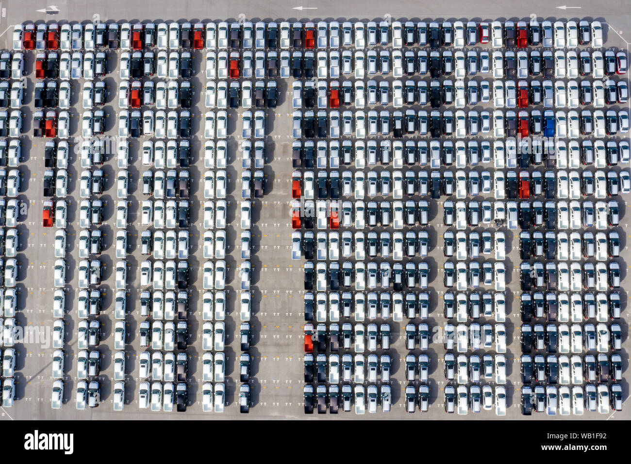 Aerial top view new cars lined up in the port for import export business logistic and transportation by ship in the open sea. New cars from the car fa Stock Photo