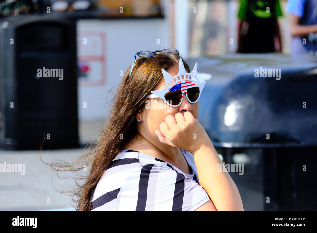Tourist wearing Statue of Liberty novelty sunglasses. Stock Photo